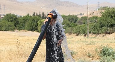 Mardin'de sıcaktan bunalan vatandaş tarım sulama hortumu ile serinledi